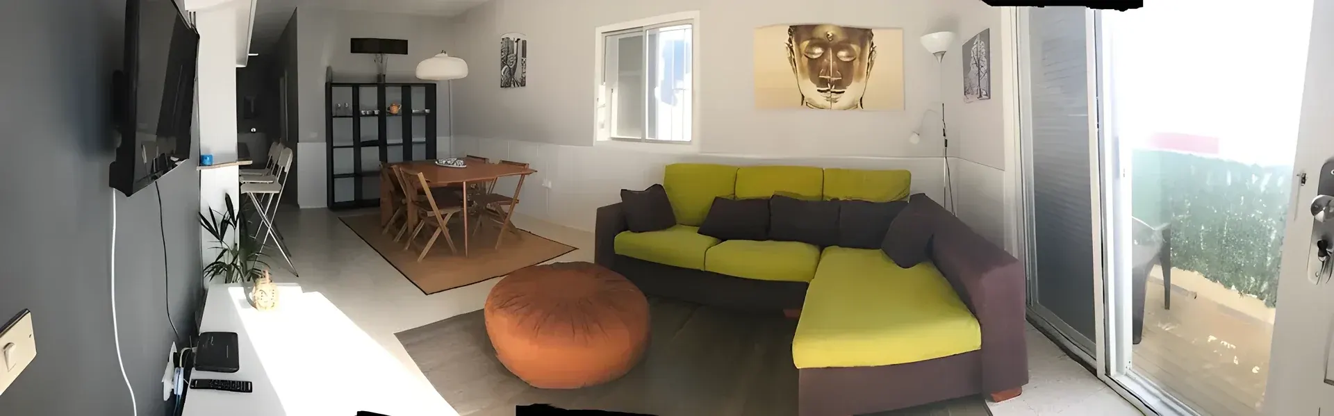 Salón comedor con sofá, mesa y salida a la terraza