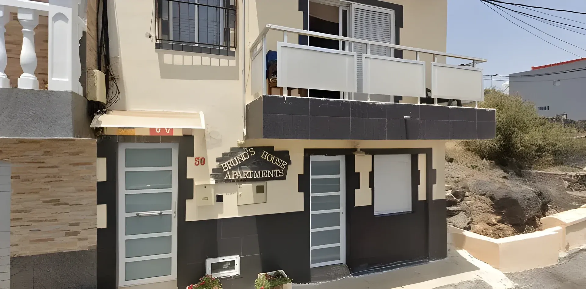 Entrada del alojamiento con el cartel de Bruno's House Apartments