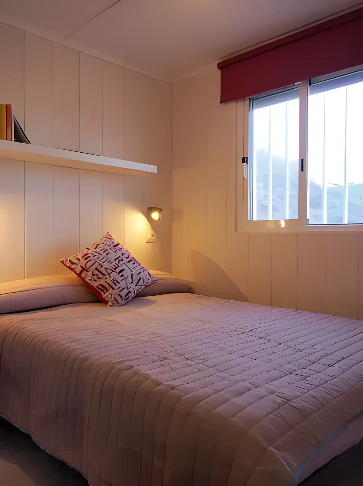 Dormitorio con cama de matrimonio y ventana al exterior